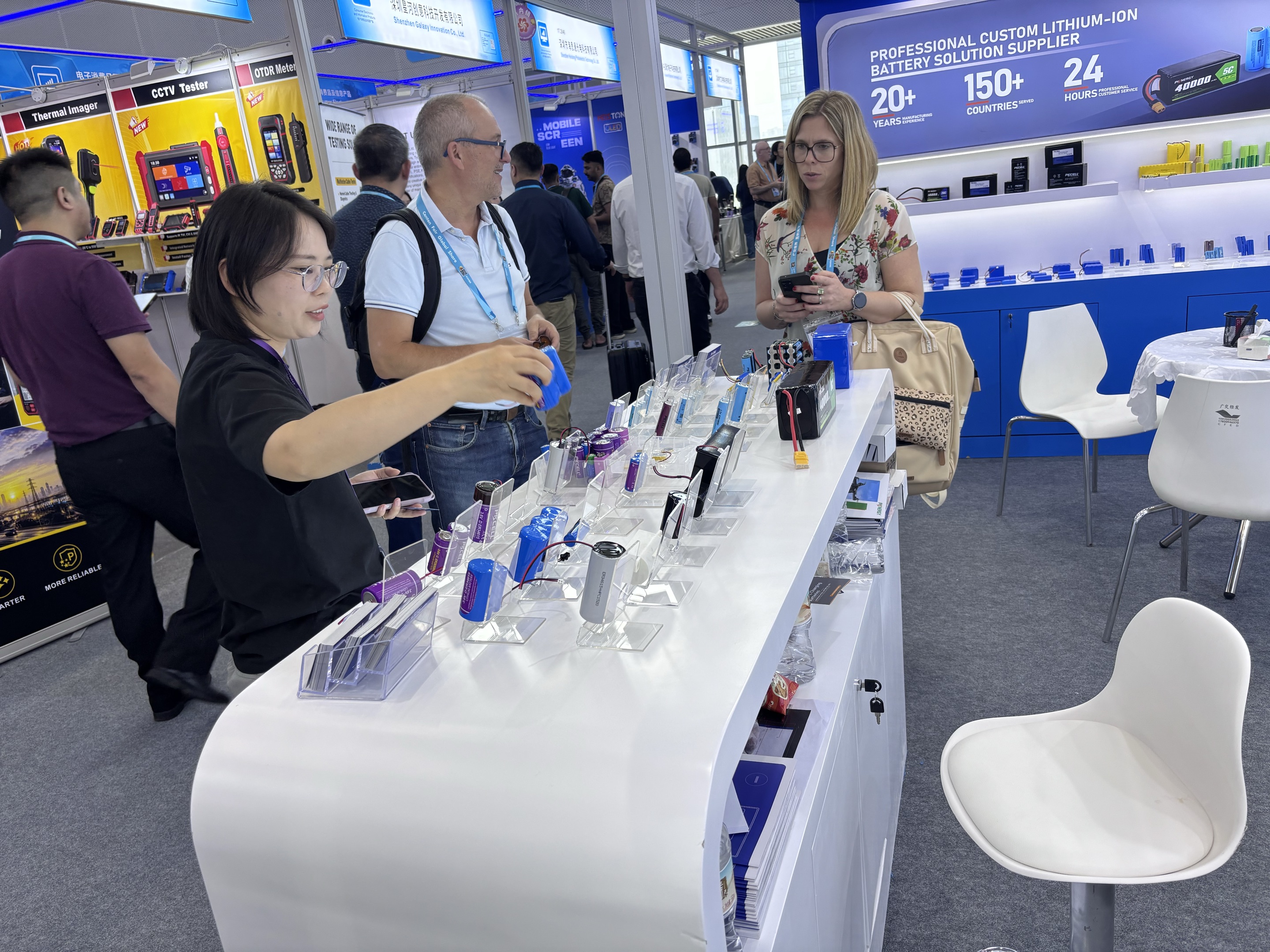 PKCELL Lithium Battery Samples and Product Display Visitors examining PKCELL lithium battery samples and cylindrical primary battery products at Canton Fair 2026
